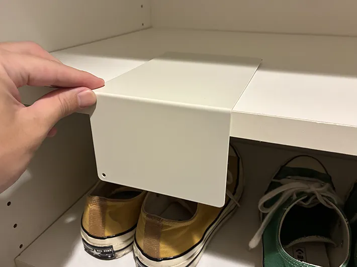 下駄箱の棚にブックエンドを置く場面（撮影：grapeライフハック編集部）