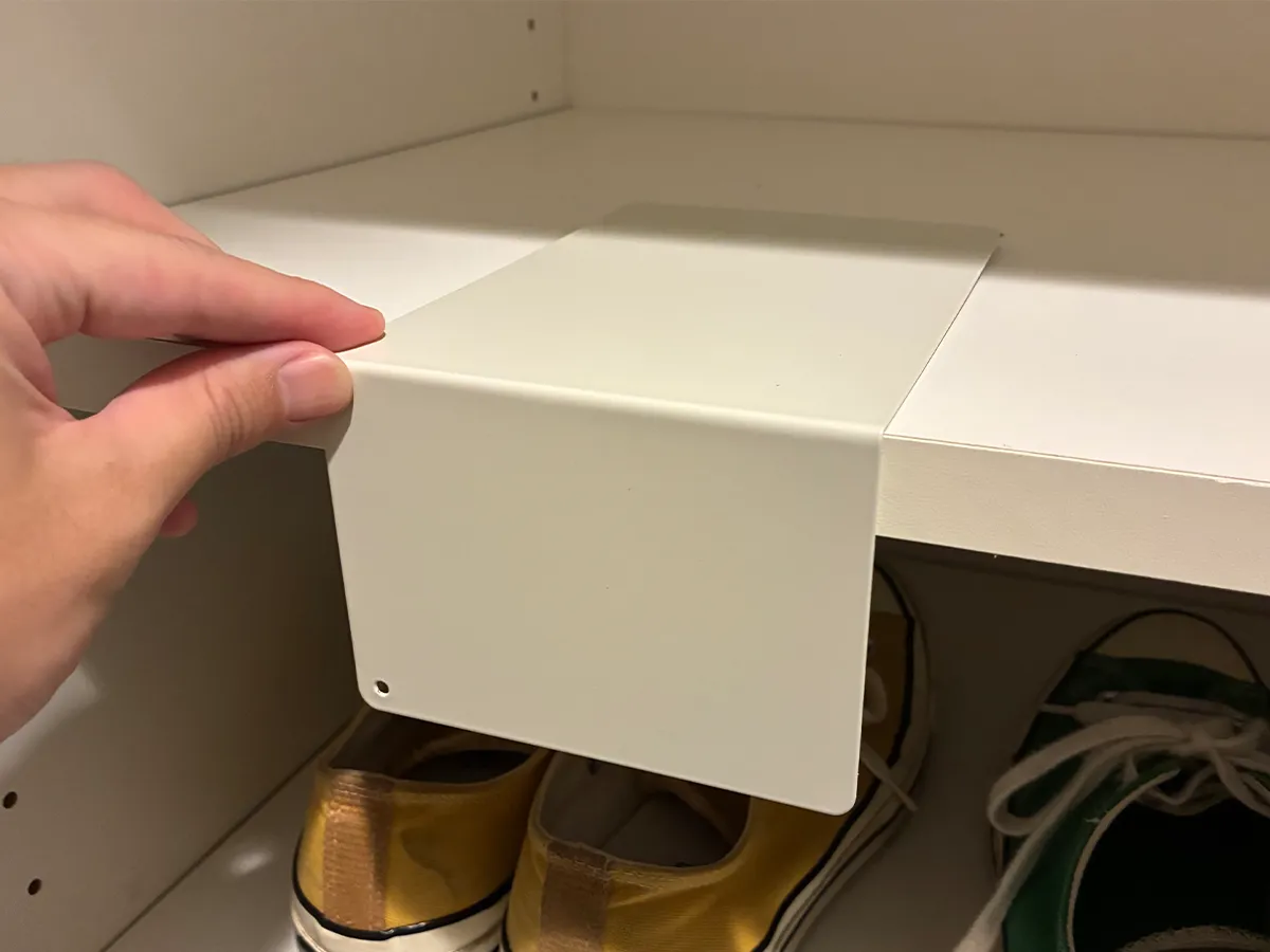下駄箱の棚にブックエンドを置く場面（撮影：grapeライフハック編集部）