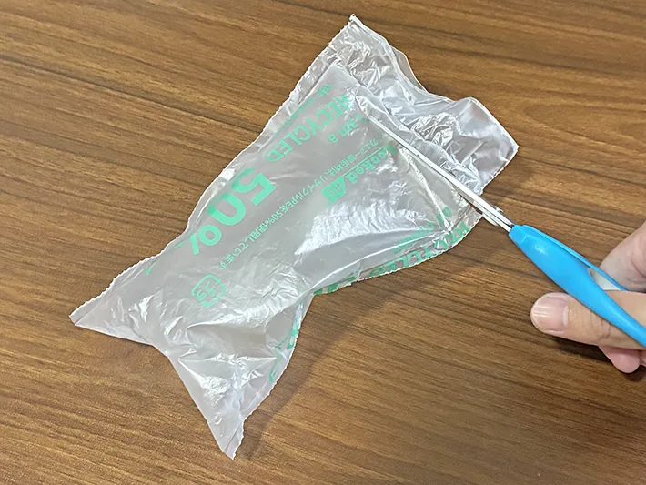 エア緩衝材の端をハサミでカットする場面（撮影：grapeライフハック編集部）