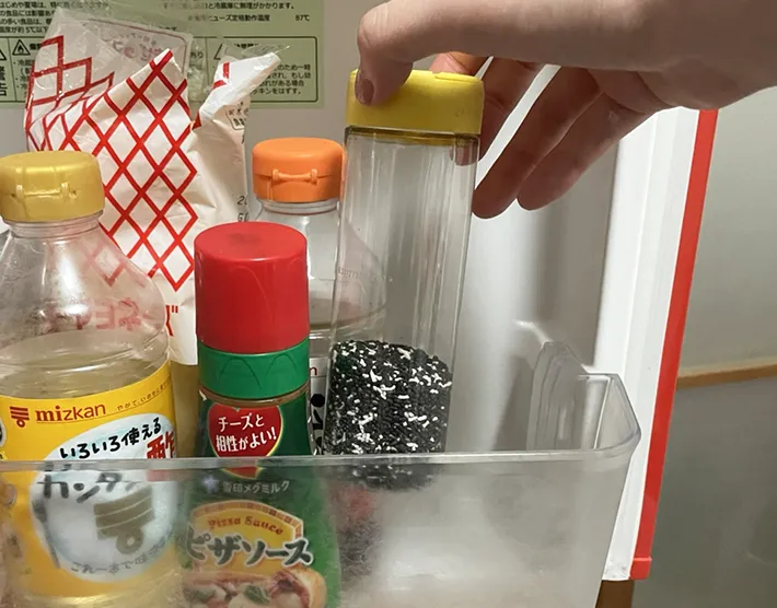 冷蔵庫に粉チーズの容器を入れる写真（撮影：grapeライフハック編集部）