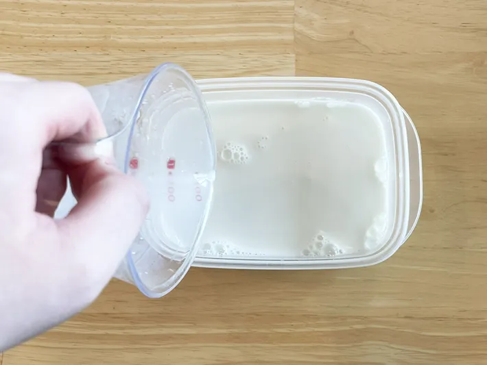 タッパーに牛乳を注ぐ写真（撮影：grapeフード編集部）