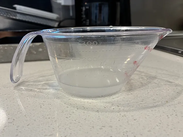 水切り後の水が入ったカップ（撮影：grapeフード編集部）