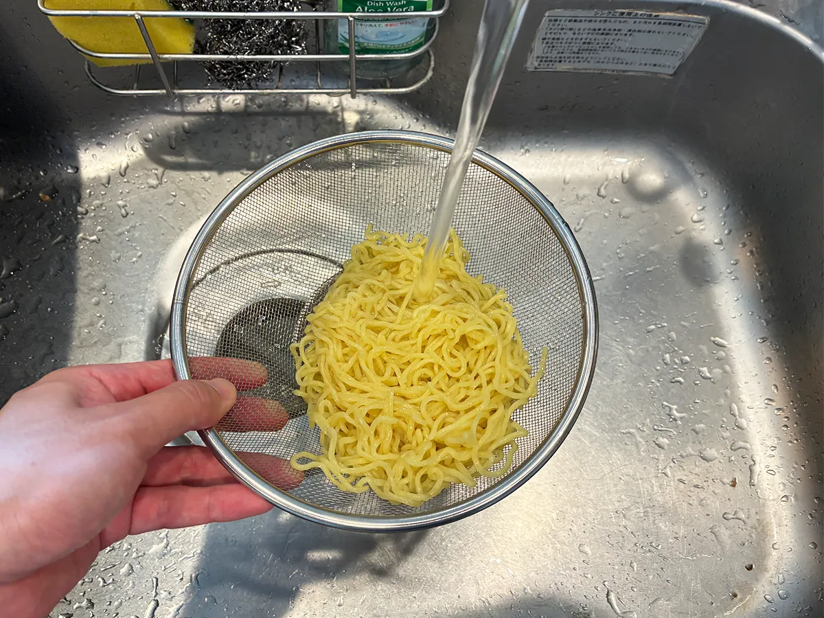 ゆでた中華麺を冷水で冷やす場面（撮影：grapeフード編集部）