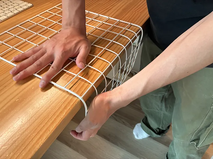 机の上でワイヤーネットを曲げる場面（撮影：grapeライフハック編集部）