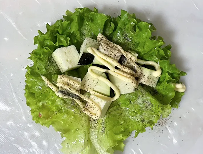 レタスの上にナス、マヨネーズ、黒コショウを重ねる写真撮影：grapeフード編集部