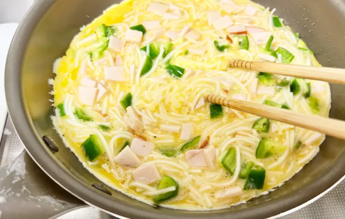 卵液をフライパンで熱しながらかき混ぜている画像（撮影：エニママ）