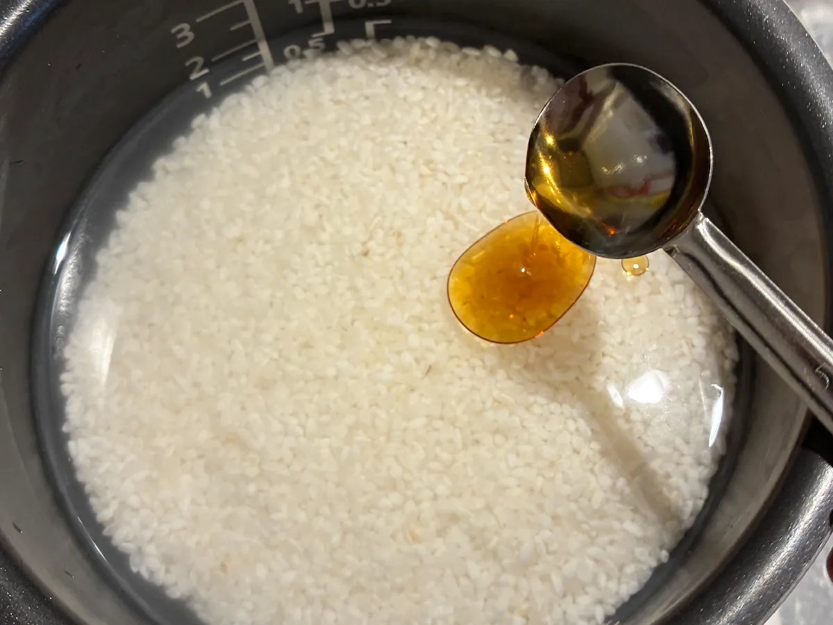 研いだお米にごま油を加える場面(撮影:grapeフード編集部)