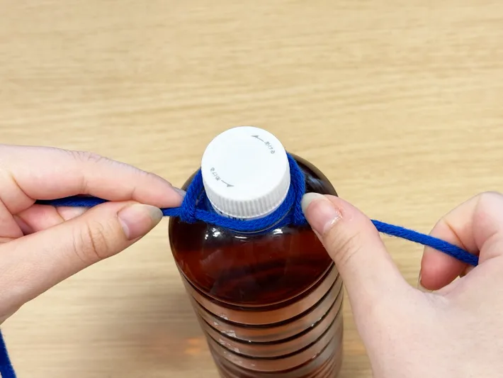 ペットボトルに紐を巻いたら強く引く（撮影：grapeライフハック編集部）