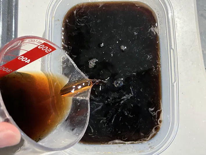 タッパーに追加のコーヒーを入れる場面（撮影：grapeフード編集部）