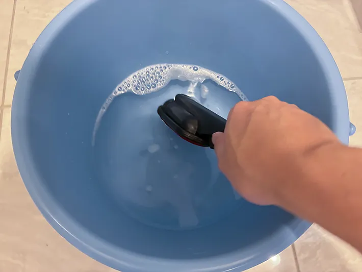 洋服ブラシを水に浸す場面（撮影：grapeライフハック編集部）