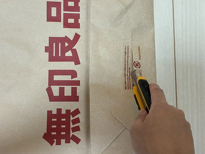 カッターで紙袋の底を切り取る場面（撮影：grapeライフハック編集部）