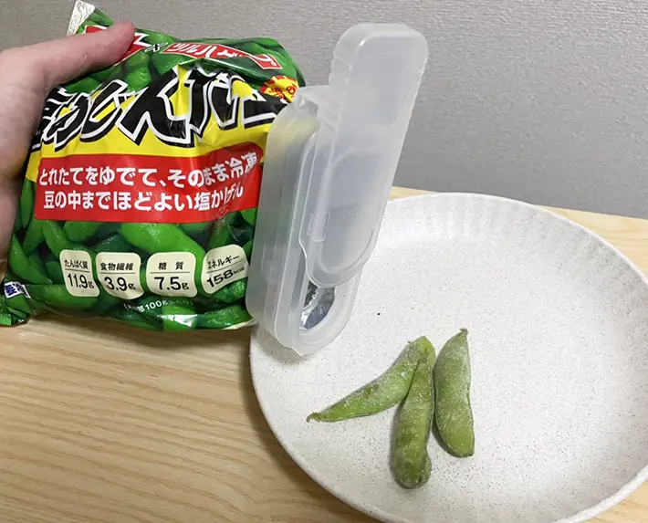 『冷凍食品用袋キャップ（小さめ食材用）』を枝豆の袋にはめて使う写真（撮影：grapeライフハック編集部）
