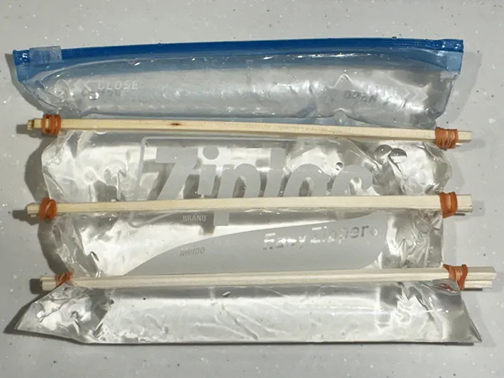 割り箸と輪ゴムで固定した水入りジッパー袋（撮影：grapeライフハック編集部）