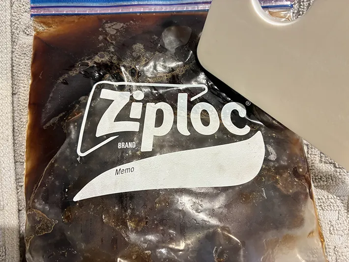 コーヒーを入れて凍らせたジッパー袋を、まな板で軽くたたく場面（撮影：grapeフード編集部）