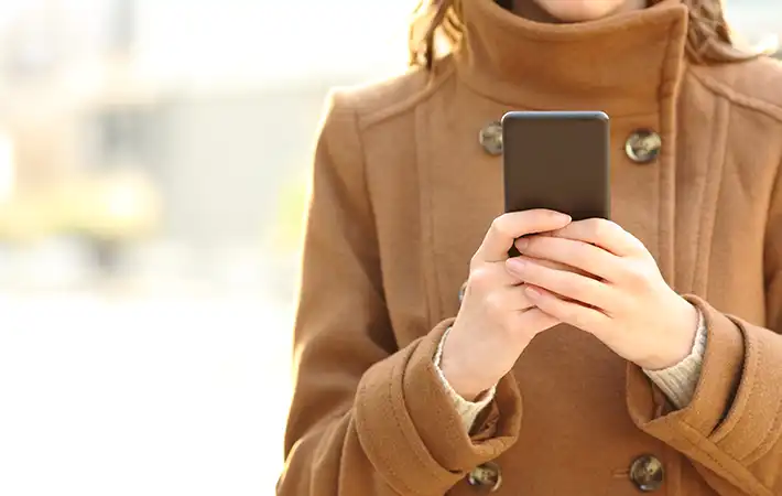 冬のコートとスマホの写真