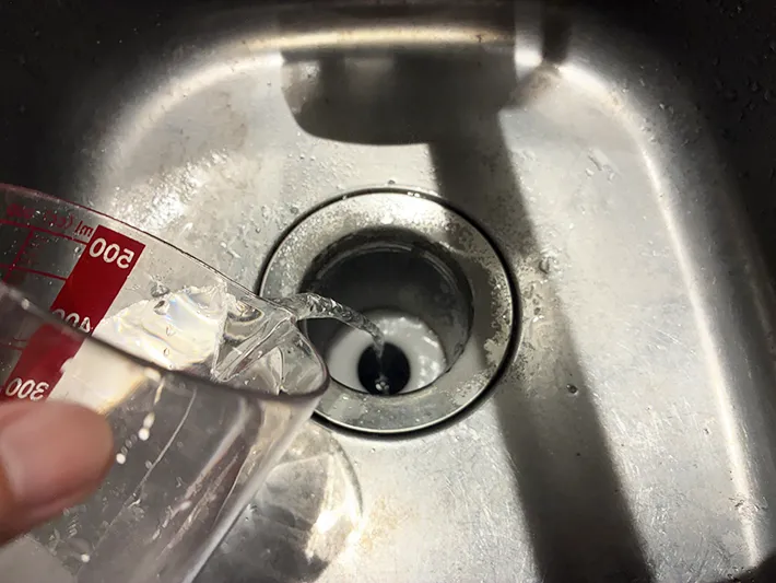 クエン酸水を排水口に注ぐ場面（撮影：grapeライフハック編集部）
