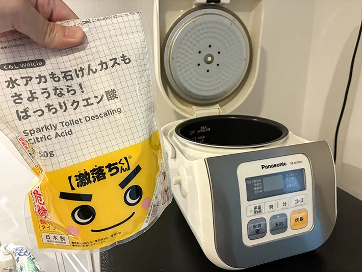 手に持ったクエン酸と炊飯器（撮影：grapeライフハック編集部）