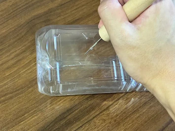 ペットボトルにキリで小さな穴を開ける場面（撮影：grapeライフハック編集部）