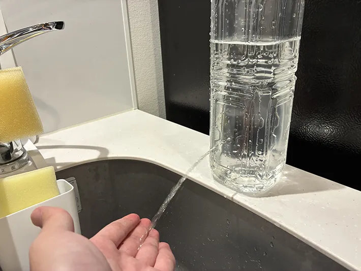 ペットボトルの小さな穴から出てくる水で手をすすぐ場面（撮影：grapeライフハック編集部）