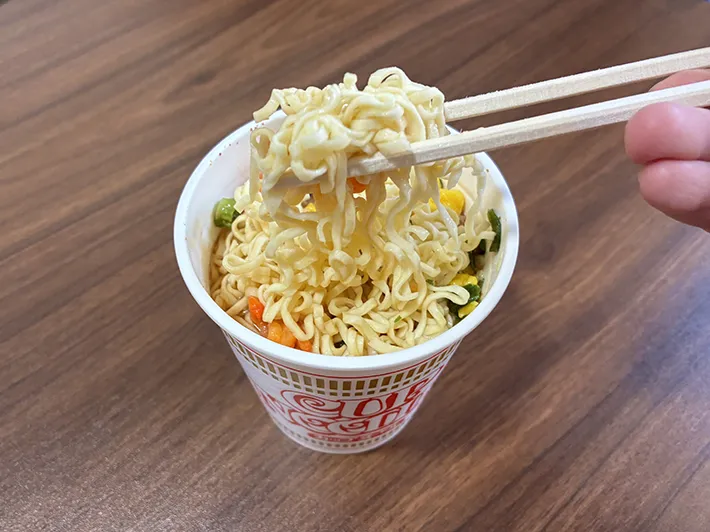 箸で持ち上げたカップヌードル（撮影：grapeライフハック編集部）