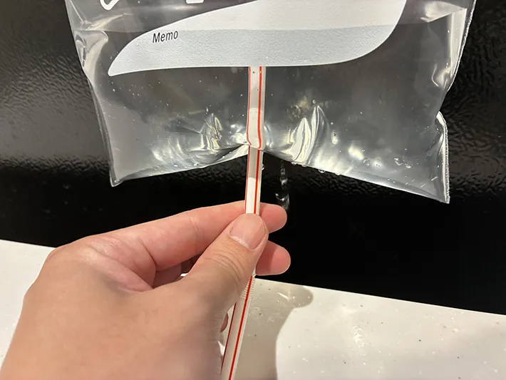 ジッパー袋の底にストローを突き刺す場面（撮影：grapeライフハック編集部）