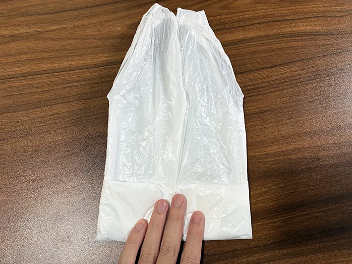 ビニール袋の左右から半分にたたむ場面（撮影：grapeライフハック編集部）