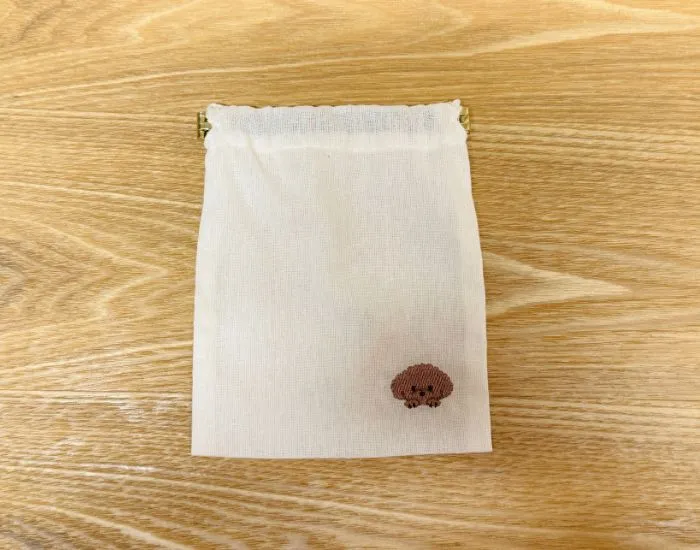 巾着袋に『バネ口金 12cm（2個入り）』を取りつけた様子（撮影：grapeライフハック編集部）