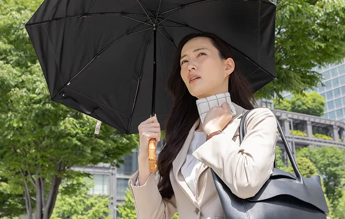 ハンカチで汗を拭く女性の写真