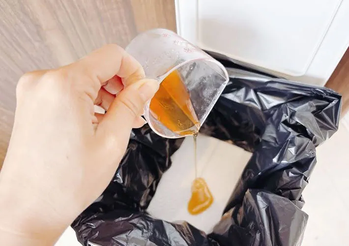 酢液をキッチンペーパーを敷いたゴミ箱に注いでいる画像（撮影：キジカク）