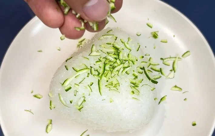 おにぎりの表面にすだちの皮をまぶしている画像（撮影：キジカク）