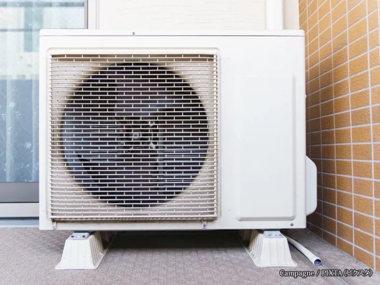 『住宅のベランダに設置されたエアコンの室外機』の写真