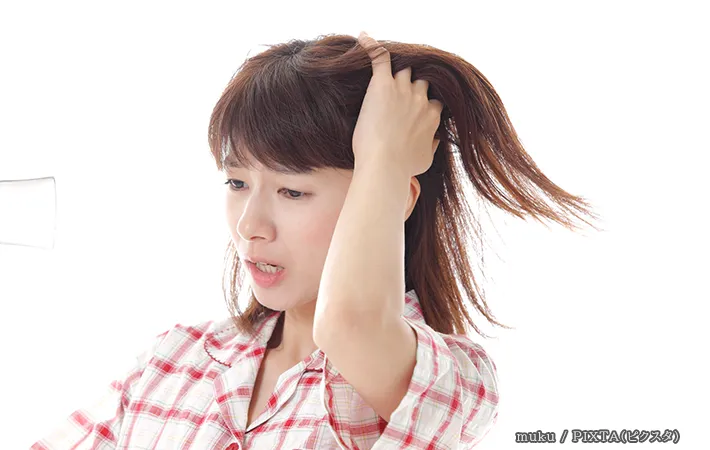 寝ぐせを押さえる人の写真