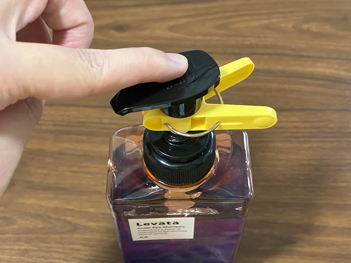 洗濯バサミのついたシャンプーのボトルを押す場面（撮影：grapeライフハック編集部）