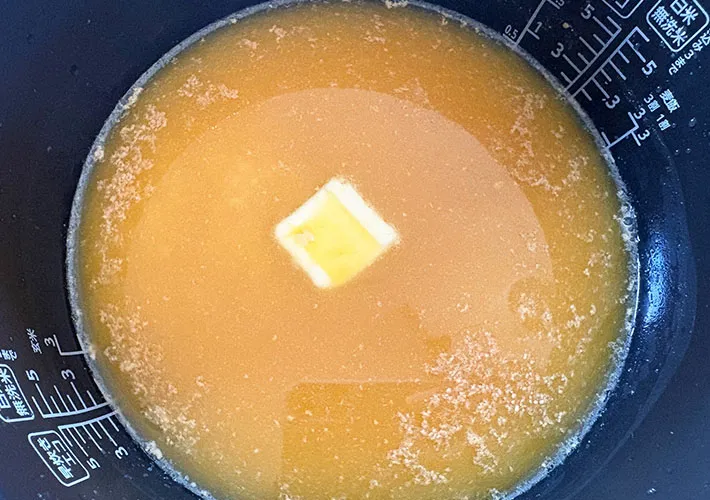 炊飯器に米とバターなどの調味料を入れた画像（撮影:エニママ）