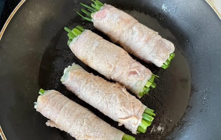 小ネギの肉巻きをフライパンで焼いている画像（撮影：エニママ）