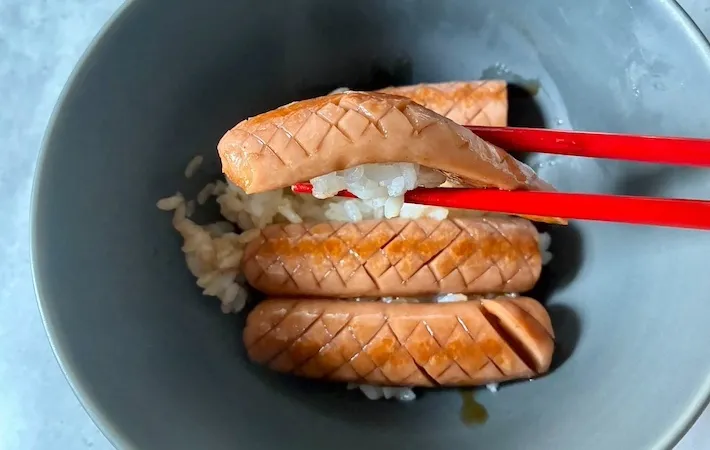 魚肉ソーセージを箸で持ち上げる画像（撮影：エニママ）