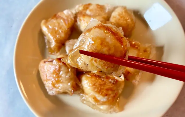 ライスペーパーチキンを箸で持ち上げている画像（撮影：エニママ）