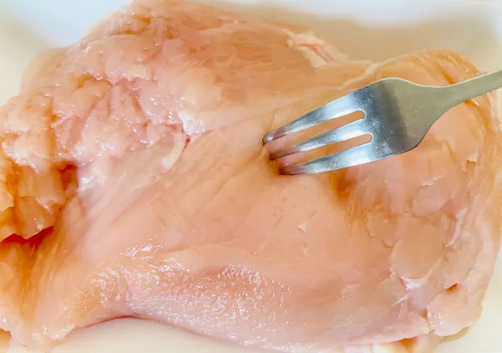 鶏むね肉にフォークで穴を開けている画像（撮影：エニママ）