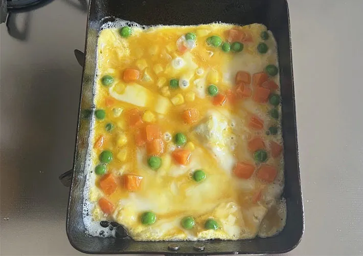 玉子焼き器に卵液を流し込み、焼いている画像（撮影:エニママ）　