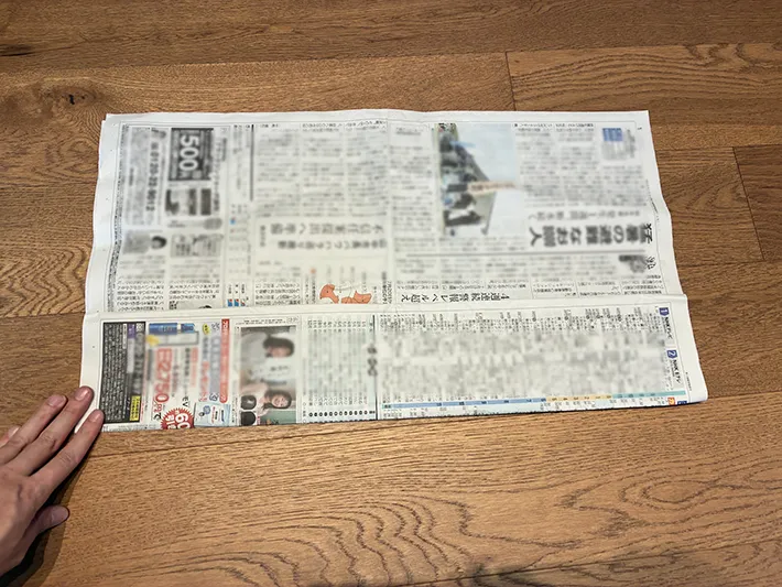 新聞紙を下から上に折る場面（撮影：grapeライフハック編集部）