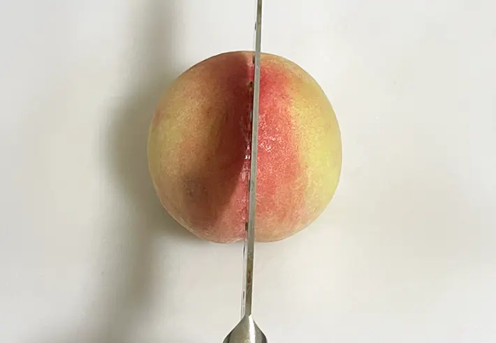 桃を縦に切る写真（撮影：grapeフード編集部）
