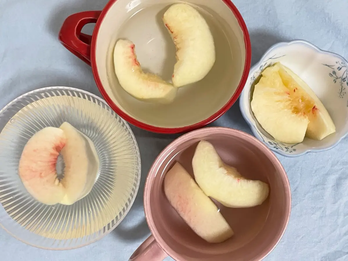 切った桃を色止め用の液に漬ける写真（撮影：grapeフード編集部）