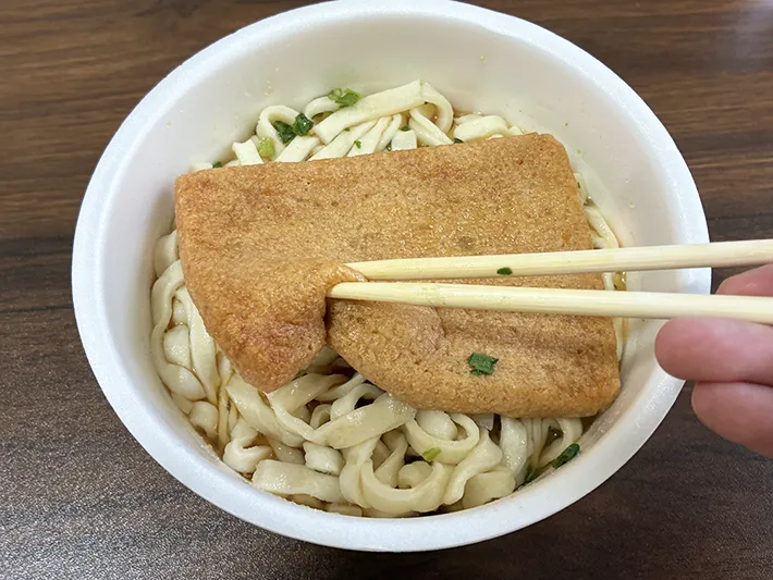 箸で押すカップうどんの油揚げ（撮影：grapeライフハック編集部）
