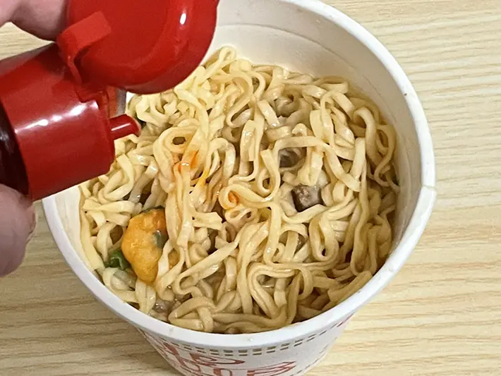 『カップヌードル』にラー油を入れる写真（撮影：grapeフード編集部）
