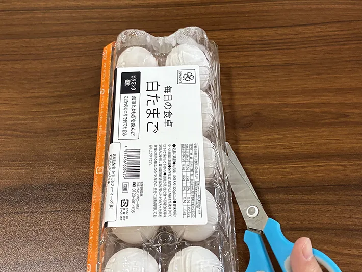 ハサミで卵パックを開ける場面（撮影：grapeライフハック編集部）