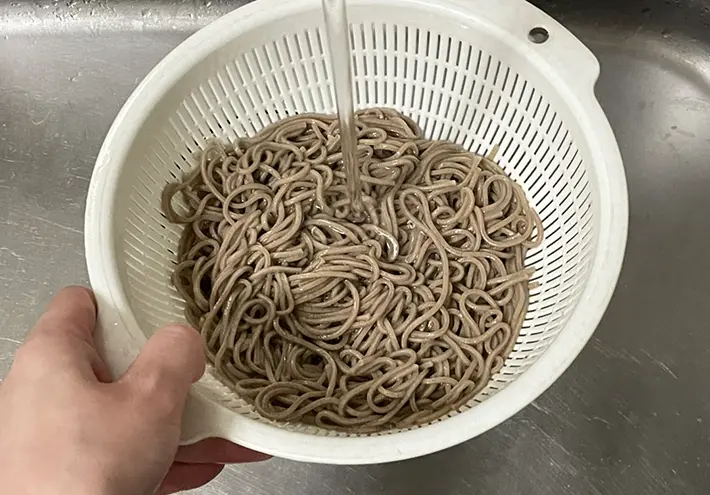 そばをザルにあげる写真（撮影：grapeフード編集部）