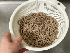 そばをザルにあげる写真（撮影：grapeフード編集部）