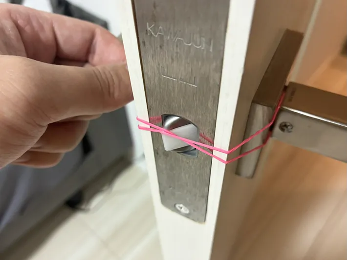 ドアノブの金具の上に置いた輪ゴム（撮影：grapeライフハック編集部）