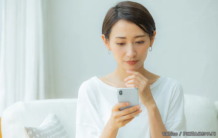 スマホを見ている女性の写真