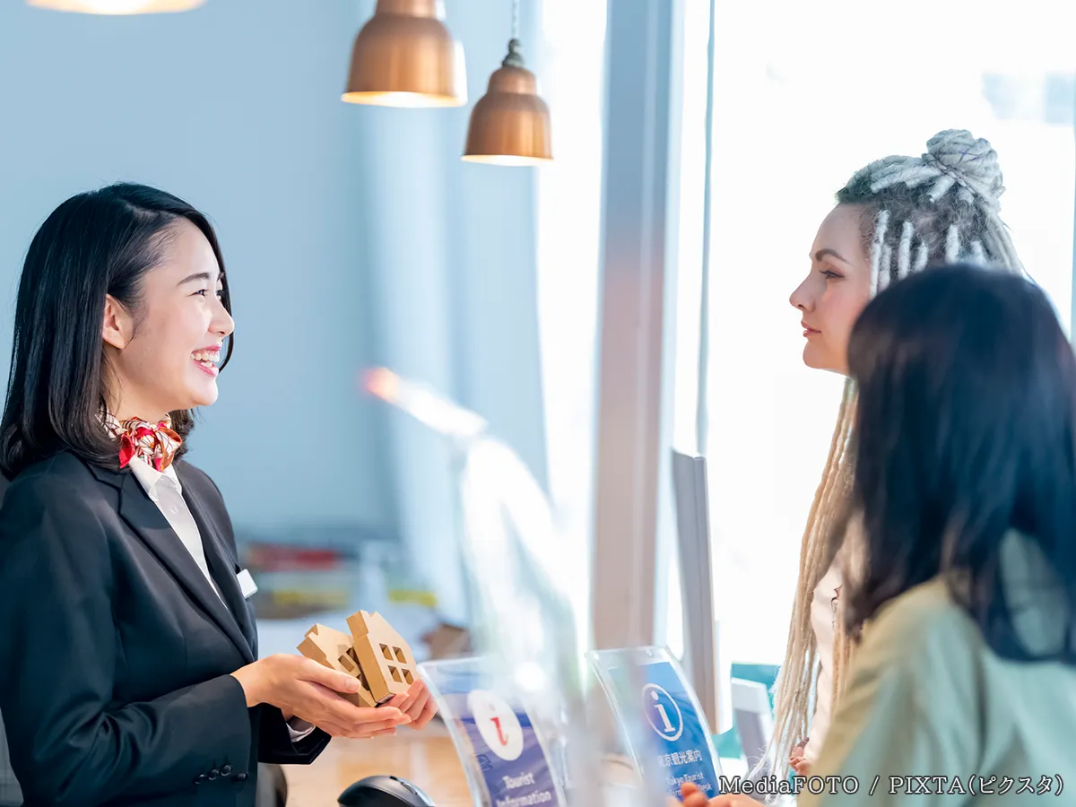 ホテルのフロントで会話する人の写真